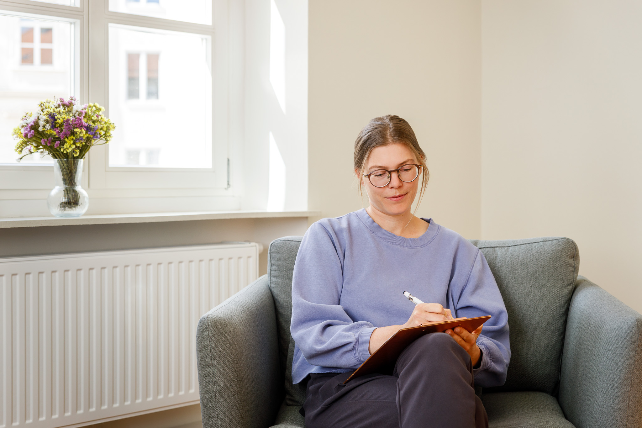 Dr. Alexandra Egger macht Notizen im Praxisraum
